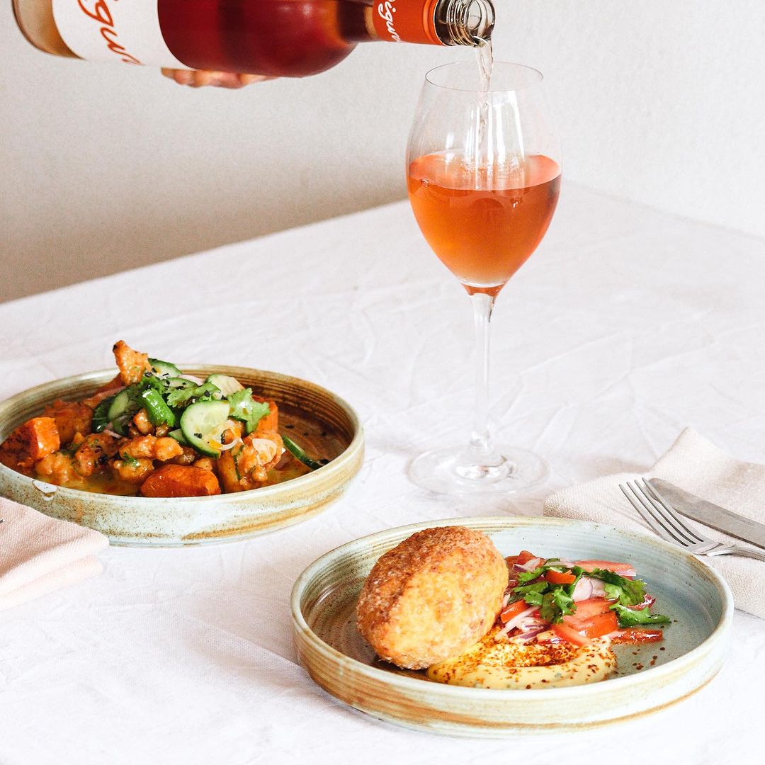 Rosé being poured beside two beautifully presented A Chef’s Pocket dishes