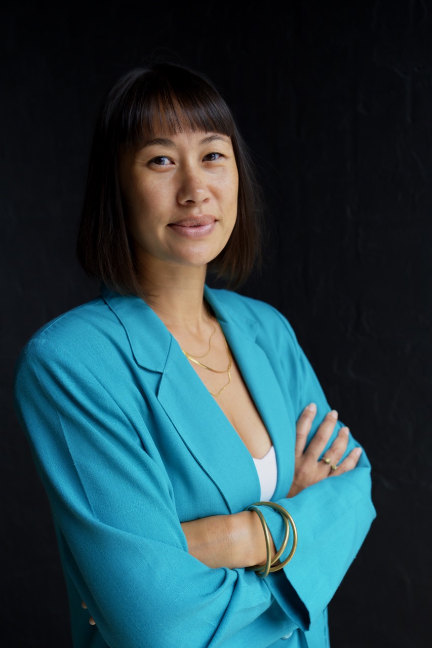 Roxanne Meik in a turquoise jacket against a dark background.